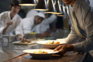 Waiter Grabbing Food in a Restaurant