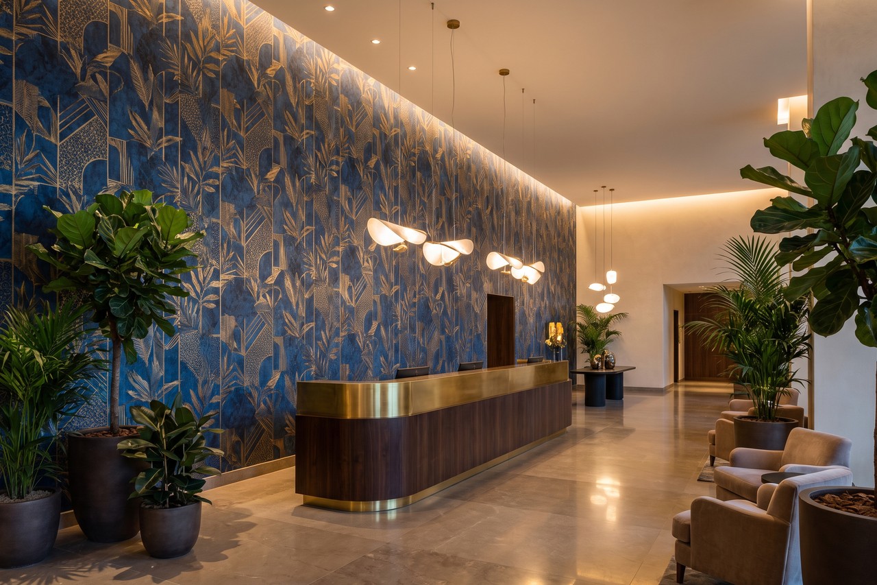 Hall di un hotel con parete di reception rivestita da carta da parati decorativa blu e oro
