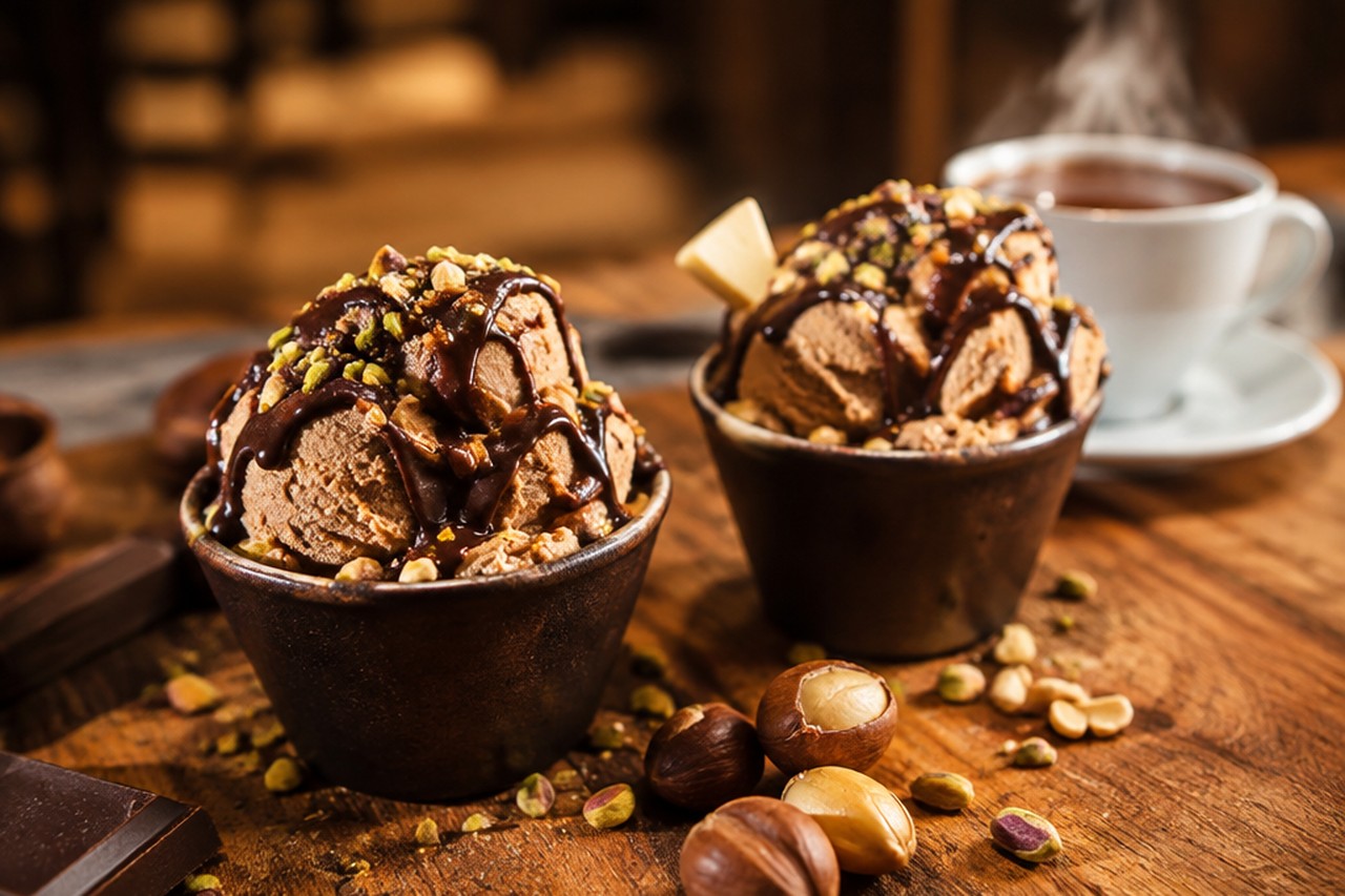 Coppa di gelato artigianale con cioccolato caldo e castagne in una gelateria in inverno